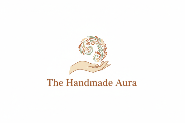 Create a minimalist logo for “The Handmade Aura”, an online store for ladies handmade bags.
Design a stylized hand gently holding a swirling floral or paisley pattern representing creativity and craftsmanship.
Use earthy tones like brown, beige, and sage green for a natural, artisan feel.
Typography: Elegant serif font in warm brown.
Background: Clean white for a premium handcrafted aesthetic.